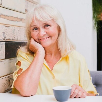 Foto de uma mulhe branca de óculos de blusa branca
